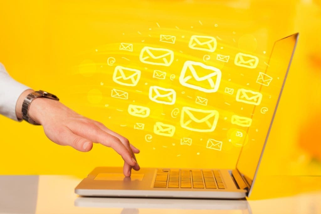 Email icons floating out of a laptop - DFY email swipes